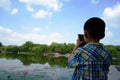 A child is concentrated on taking photoes with lotus flowers Royalty Free Stock Photo